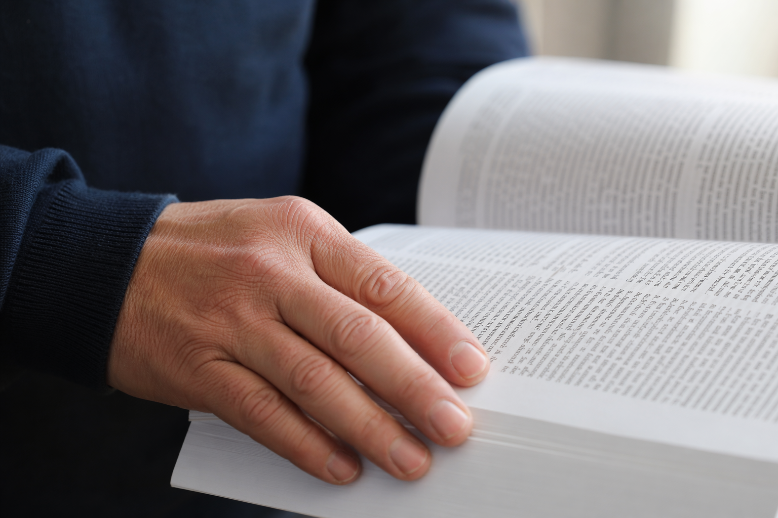 Mão correndo sobre página densa de texto jurídico